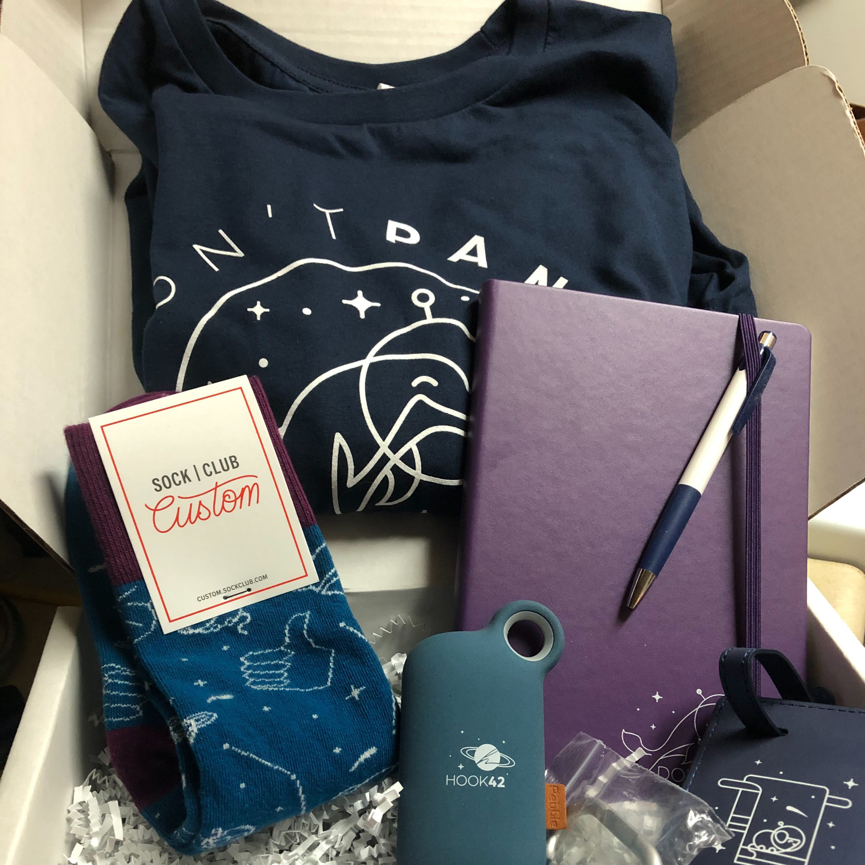 open box displaying h42 branded tshirt socks and notebook