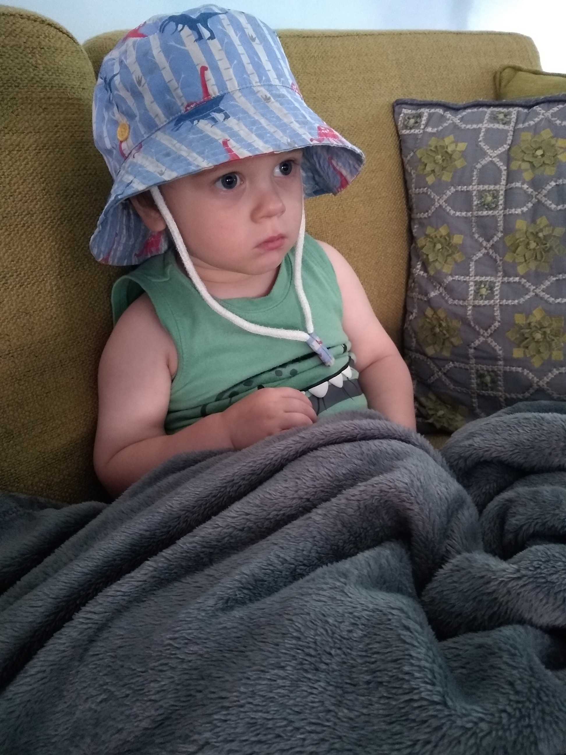melissa's son will snuggling under blankets in a dinosaur hat