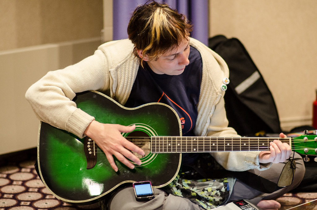 Cathy Theys (YesCT) strumming guitar at DrupalCon Prague by Josef Jerabek