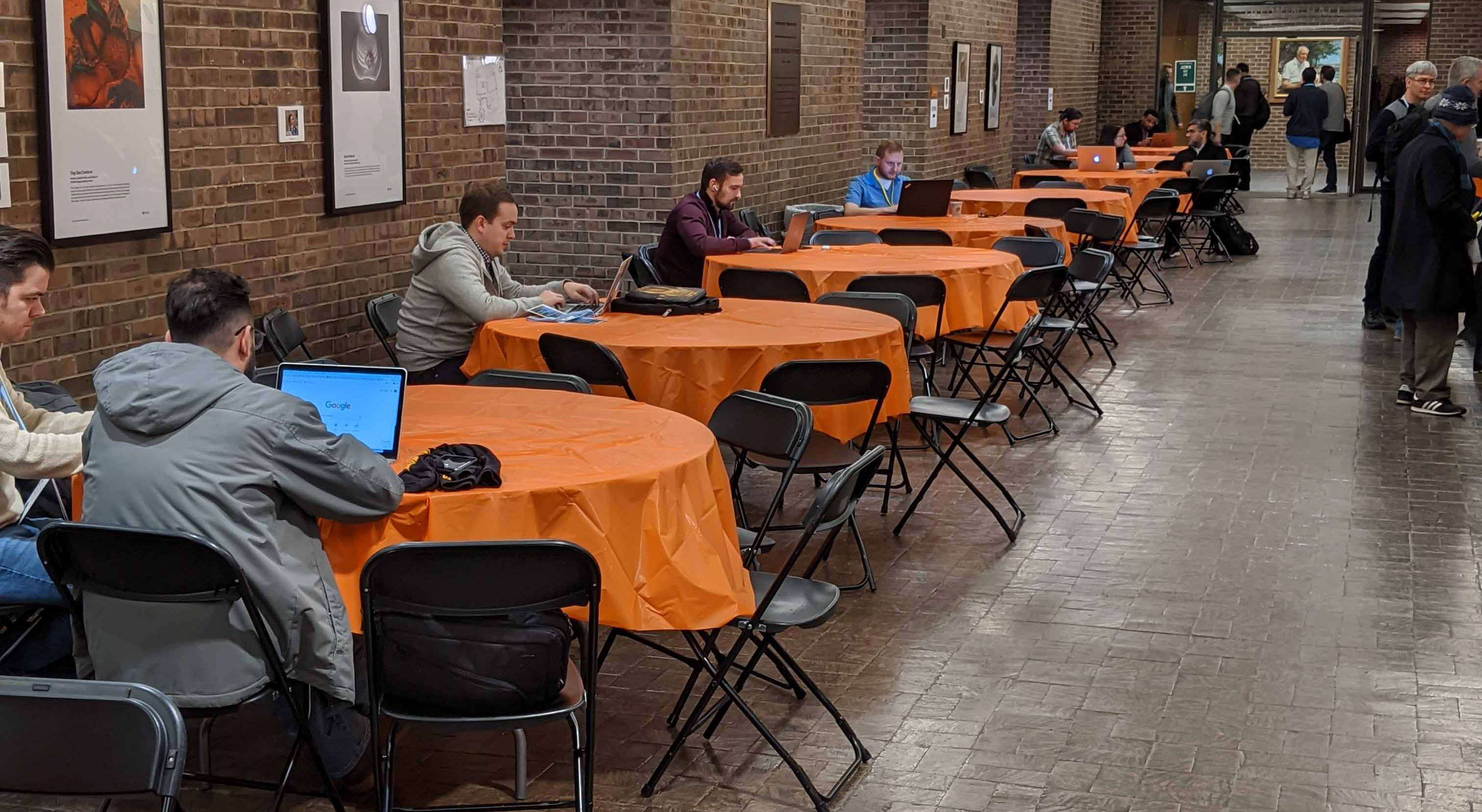 conference tables with orange table cloths and black chairs