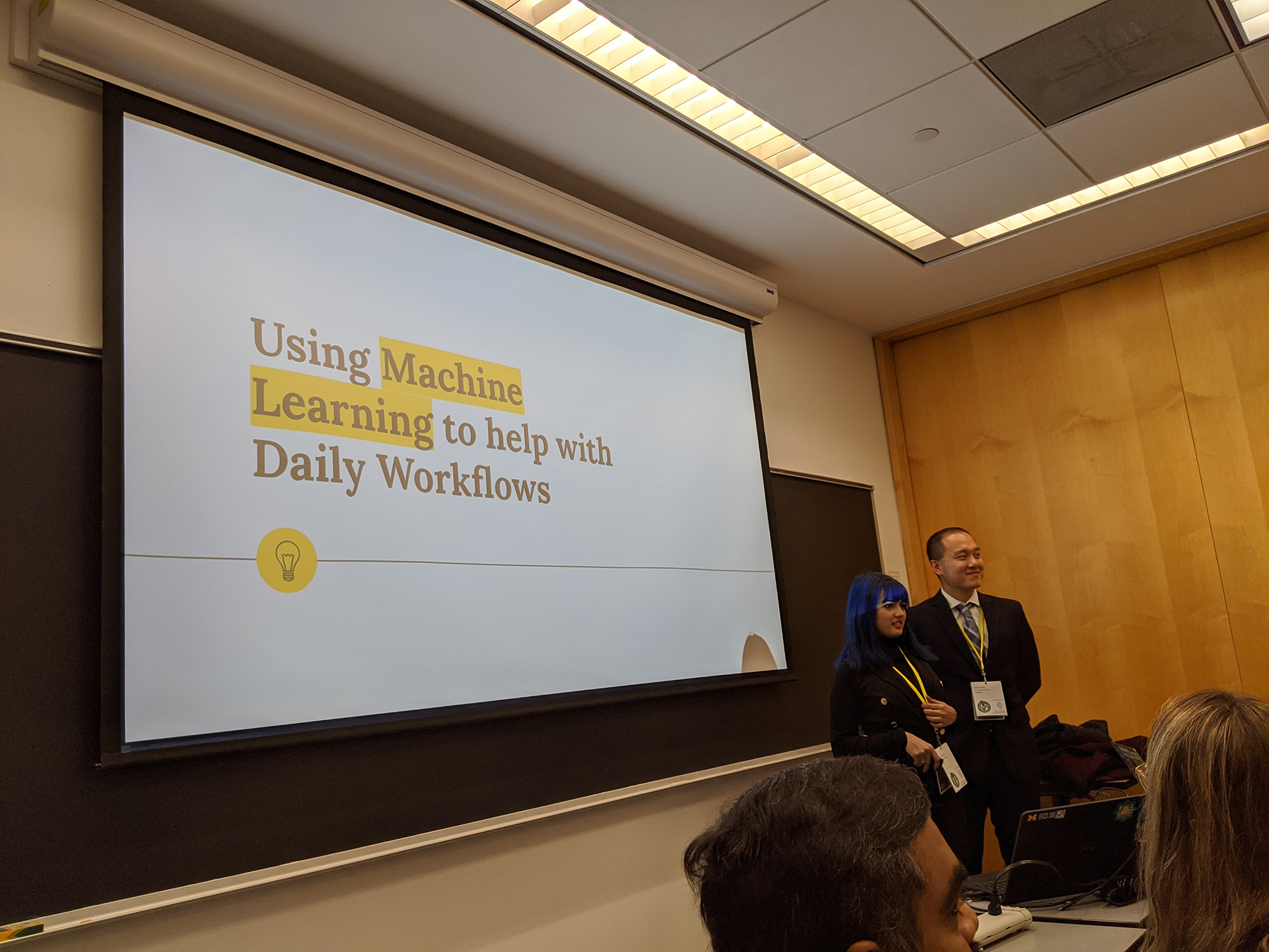 Danny Teng and Neha Bhomia standing in front of presentation title screen