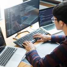 developer setting up work environment on three screens
