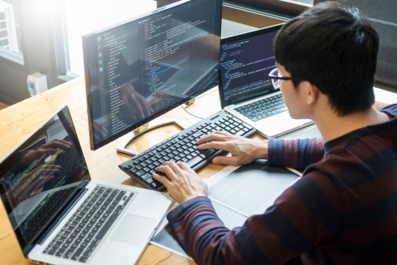 developer setting up work environment on three screens