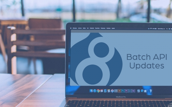 Open laptop in coffee shop with Batch API Updates and Drupal 8 logo on screen