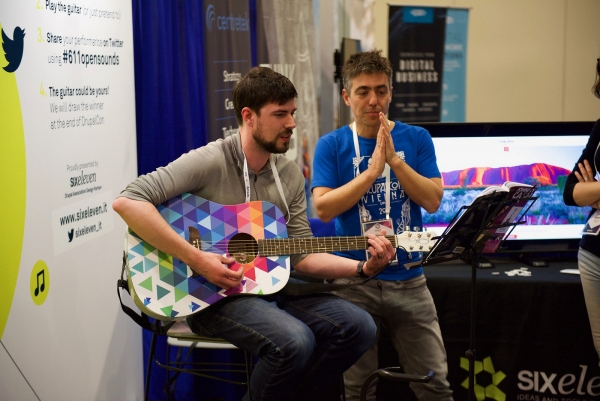 Ryan Bateman playing the guitar in the expo hall at DrupalCon Nashville