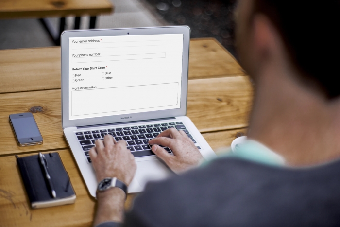 Man coding form fields on laptop